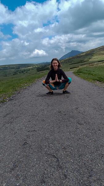 Jogový drep. Ruky sú spojené a dlane smerujú k sebe.