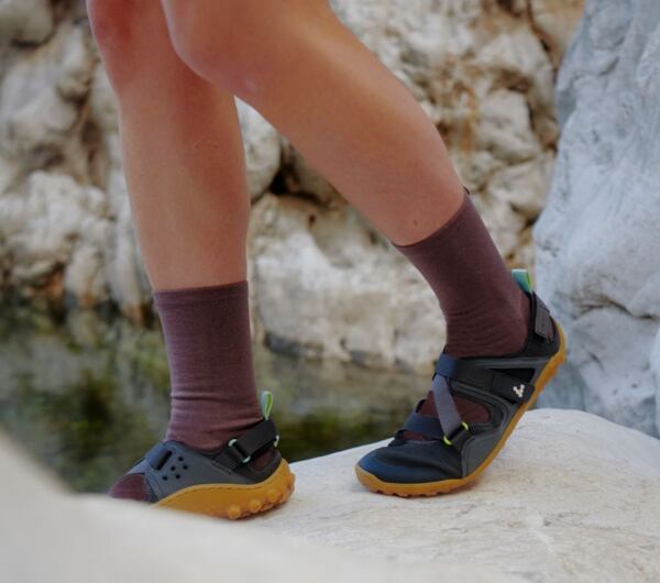 Záber na nohy v skalách v sandáloch naboso.
